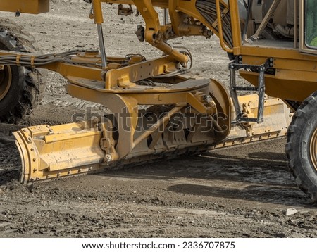 Grader road construction Grader industrial machine building new roads. the blade of a motor grader leveling a sandy road foundation.