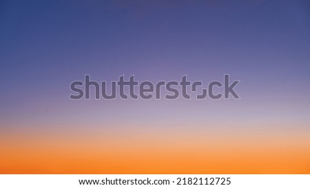 Gradient of orange-blue evening sky without clouds at sunset