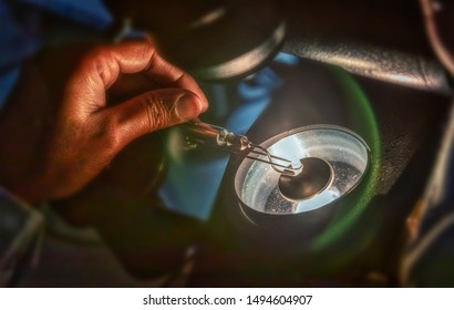 grading clarity on diamonds, microscope and magnifing glass, african woman working