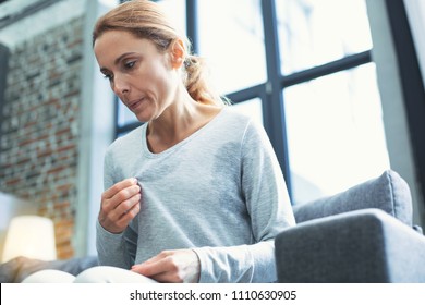 Gradual process. Beautiful mature woman touching sweater and having hot flash - Shutterstock ID 1110630905