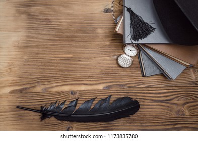 Graduate cap, pocket watch and stack of books on the wooden school desk with copy space.