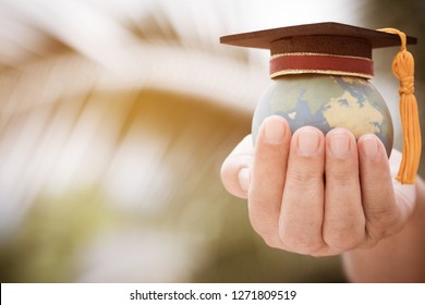 Graduate Or Education Knowledge Learning Study International Abroad Concept : Graduation Cap On Opening Textbook With Blur Earth World Globe Model Map In Outdoor Of Campus, Back To School 