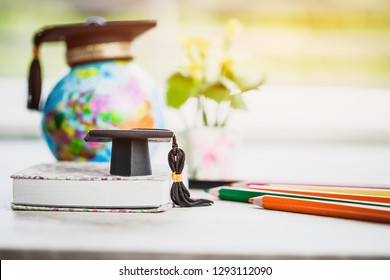 Graduate or Education knowledge learning study abroad concept : Graduation cap on book with blur of Europe earth world globe, with color pencils on wood floor. Work and travel. Back to School - Shutterstock ID 1293112090