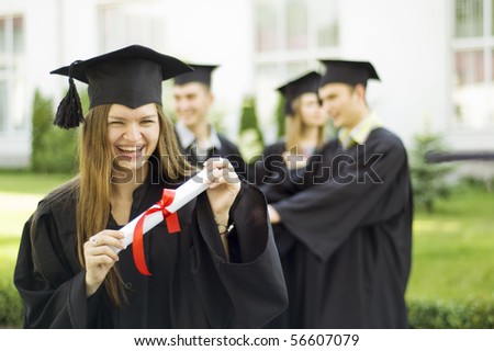 A graduate holding a diploma and smiling. A beautiful girl graduate at the graduation ceremony. Graduation of masters. Graduate look at the camera.