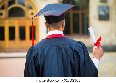 Graduate Student Hands Holding Diploma From The Back