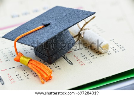 Graduate study abroad program concept : Graduation cap on a paper calendar and a scroll of certificate nearby. Graduate study abroad program is a program that accept students from foreign countries.