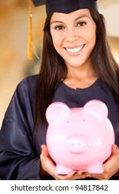 Graduate woman holding a piggybank with her education savings
