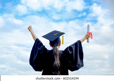 Graduate woman students wearing graduation hat and gown, back view of graduate student girl hug future and look up to copy space, she wear graduation cap and gown ,asian woman
