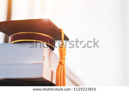 Graduated or Graduation university study abroad international Conceptual, Congratulations to graduates hat on textbooks stack in classroom. Studies lead to success in Goal life. Back to School