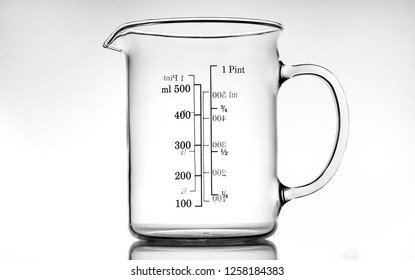 graduated measuring cup in pyrex on a white to gray background