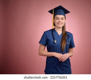 Graduated Nurse In Blue Uniform In Graduation Cap Standing, Looking Forward