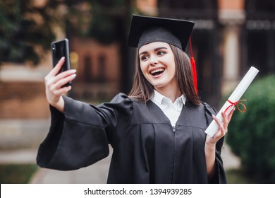 Graduated Student In Graduation Hat And Gown , Outdoors Make Joint Selfie!