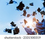 Graduating students hands throwing graduation caps in the air.