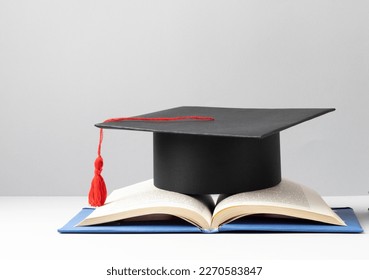 graduation cap and an open book for education day