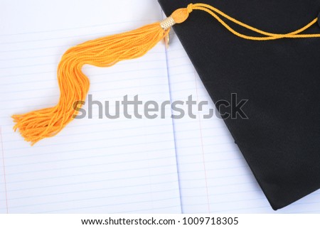 graduation cap tassle and notebook paper background