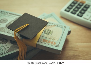 Graduation cap university on stack US dollar banknote, calculator. Education expense budget plan of money savings, student loan or debt, personal loan, scholarship for studying abroad, tuition concept