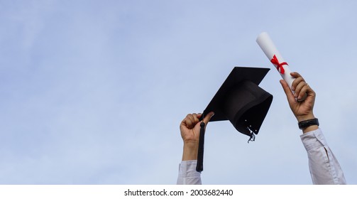 Graduation Day,A Certificate And A Mortar Board In Hand With Sky Background, Happiness Feeling,Congratulation.