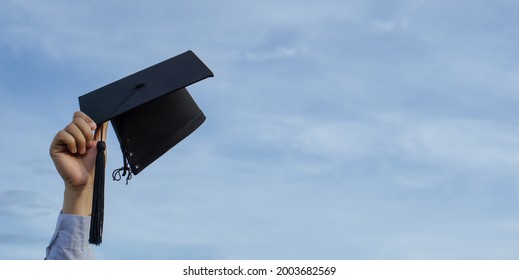 Graduation Day,Mortar Board In Hand With Sky Background, Happiness Feeling,Congratulation.