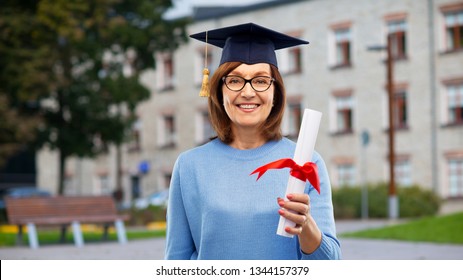 Graduation, Education And Old People Concept - Happy Senior Graduate Student Woman In Mortar Board With Diploma Laughing Over University Campus Background