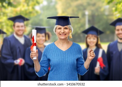 Graduation, Education And Old People Concept - Happy Senior Graduate Student Woman In Mortar Board With Diploma Over Group Of Students Background