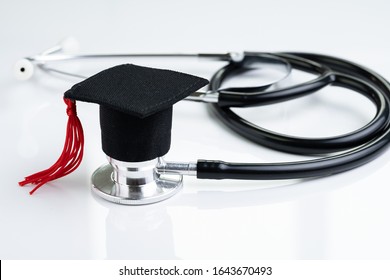 Graduation Hat On Doctor Stethoscope, White Background Using As Medical School, Health Care Education Or Doctor's University Degree Concept.