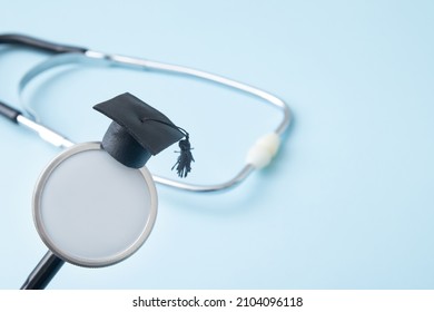 Graduation Hat On Doctor Stethoscope Mock Up, Blue Background With Copy Space. Medical School, Health Care Education Or Doctor's University Degree Concept