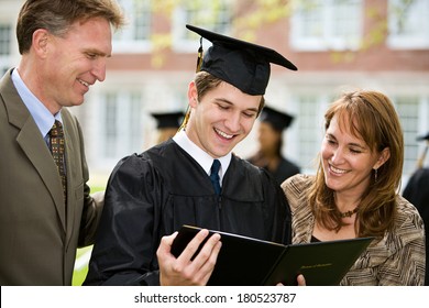 Graduation: Male Student Stands Proudly With Parents