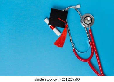 Graduation Medical Concetp. Graduation Cap, Diploma And Stethoscope On Blue Background