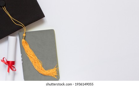 Graduation top view concept. Notebook, academical hat and diploma. Copy space