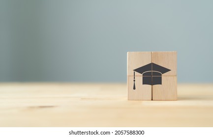 Graduation from university, education, diploma concept. Happiness cheerful feeling, Commencement, Graduation day. The wooden cubes with graduation cap on beautiful grey background and copy space.