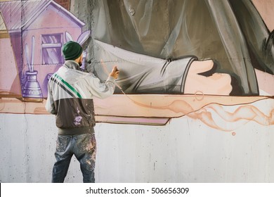 Graffiti Artist Painting With Aerosol Spray On The Wall