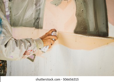 Graffiti Artist Painting With Aerosol Spray On The Wall