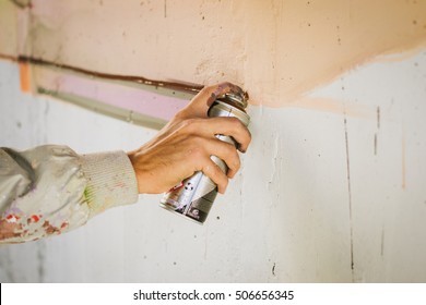 Graffiti Artist Painting With Aerosol Spray On The Wall