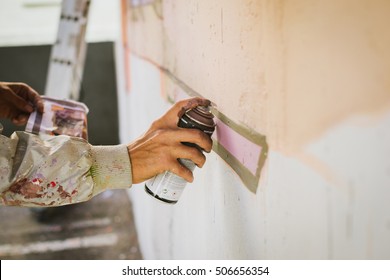 Graffiti Artist Painting With Aerosol Spray On The Wall