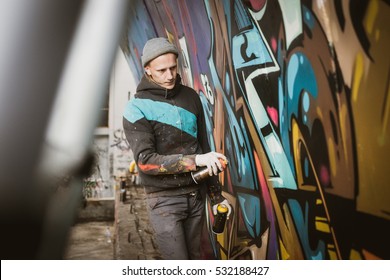 Graffiti Artist Painting With Aerosol Spray On The Wall