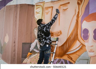 Graffiti Artist Painting On The Wall