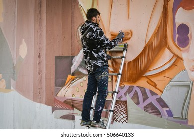 Graffiti Artist Painting On The Wall