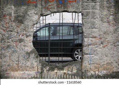 Graffiti And Greetings On One Of The Remaining Sections Of The Old Cold War Berlin Wall - Germany. This Section With A Big Hole To Freedom.... Car Driving By.