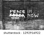 Graffiti, peace now. Korea, Vietnam. Brick wall.