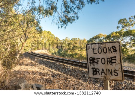 Graffitied warning sign at a railway crossing, Adelaide Hills, Australia