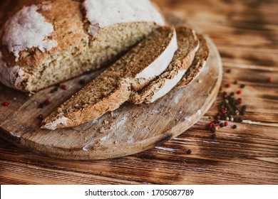 Grain Artisan Bread Loaf. Rustic loaf of homemade bread sliced on dark wooden table. Homemade Loaf Of Bread. Selective focus