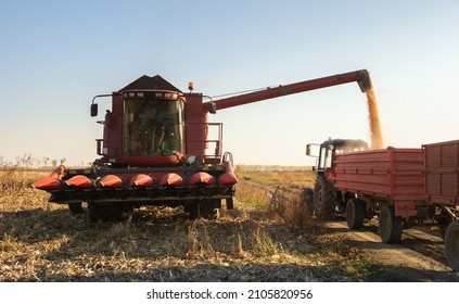 Grain Auger Of Combine Pouring Corn Into Tractor Trailer