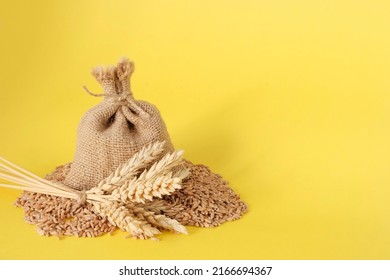 Grain, Bag Of Wheat. Yellow Background. The Concept Is A Symbol Of The Harvest, The Food Crisis During The War. Import, Export Of Grain. Agriculture.