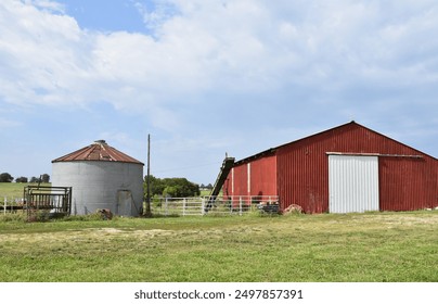 Grain bin and red barn in a farm field - Powered by Shutterstock