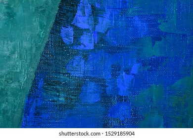 Grain canvas surface with several layers of blue and green oil paint. Large strokes of saturated blue on a darker deep blue primer. A fragment of a painting. Modern Art.