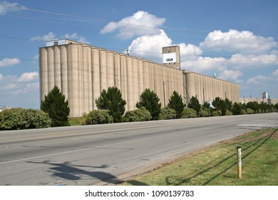 Grain Elevator In Rural Saginaw Texas With Caution Gas Line Marker In Foreground 