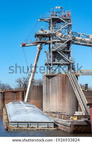 Grain elevator terminal barge spout loading grain corn into barge on Mississippi River, transport, export, storage container, silos, marine, maritime, logistics, equipment, tower, cargo, dry goods