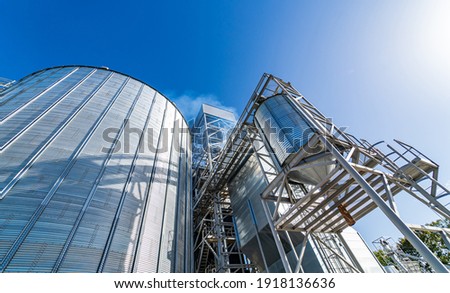 Grain elevators for crop storage. Metal bridge from the roof of metal tank. View from below. Closeup.