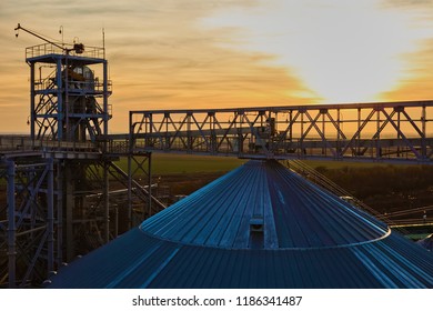 Grain Silo And Dryer At Night With Pile Of Grain.