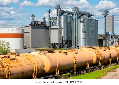 Grain silo next to railroad tracks with set of cargo trains